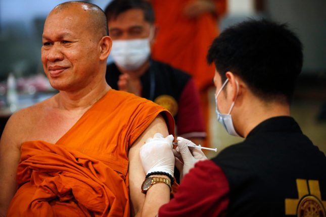נזיר תאילנדי מקבל את החיסון לקורונה. צילום: שאטרסטוק