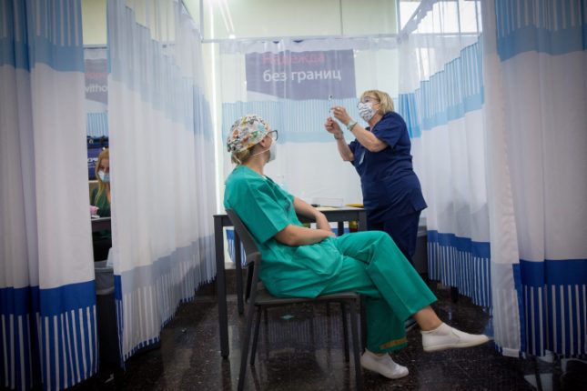 חברת צוות רפואי ב"שיבא" מתחסנת לקורונה. צילום: מרים אליסטר/ פלאש 90